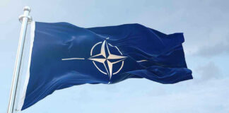 NATO flag waving against blue sky