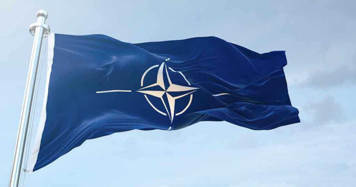NATO flag waving against blue sky