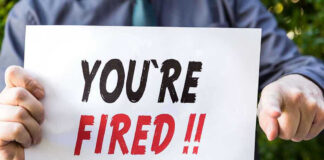 Person holding YOURE FIRED sign