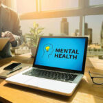New Study: Youth Crisis Outpaces Midlife Blues Laptop displaying Mental Health screen in an office