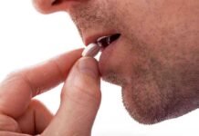 Brain Pill Scandal—What’s Really Inside? Close up of a man preparing to take a pill