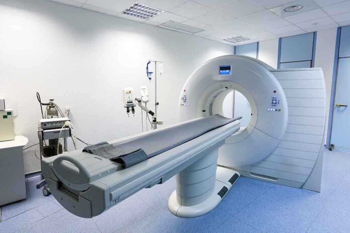 A CT scanner in a hospital room with medical equipment nearby