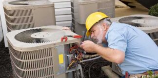 HVAC technician repairing an air conditioning unit outdoors