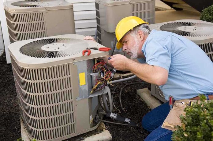 shutterstock_223543426.jpg HVAC technician repairing an air conditioning unit outdoors