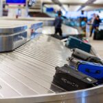 Scammers Exploit Airport Tags—Nobody’s Safe Luggage on a conveyor belt at an airport baggage claim area
