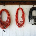 2025 Remodeling Crisis: Who’s Really to Blame? Three extension cords hanging on a wall with a power outlet
