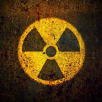 Yellow radiation warning symbol on rusty metal surface
