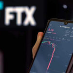 Hand holding phone with FTX trading app