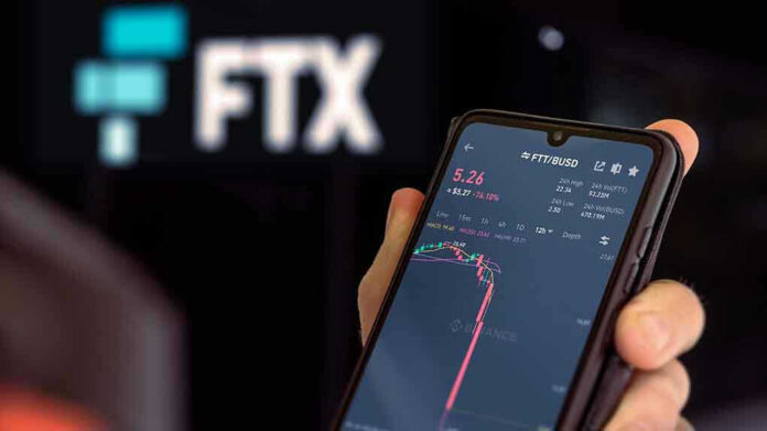 Hand holding phone with FTX trading app