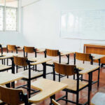 Empty classroom with desks chairs and whiteboard