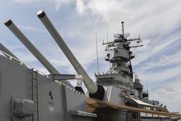 shutterstock_224332015.jpg Close up of a battleships naval guns and superstructure against a cloudy sky