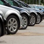 A row of parked black and silver cars in a dealership