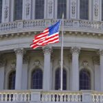 American flag waving in front of the Capitol building
