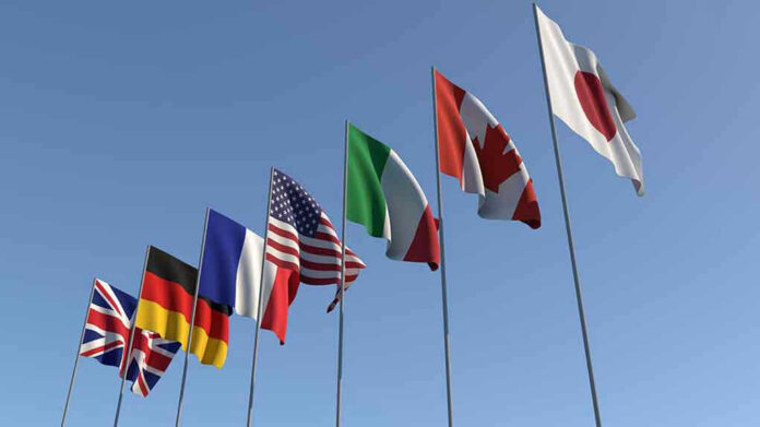 1437085796 Flags of seven countries against clear blue sky.