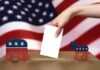 Shocking Blunder Disqualifies 34 Candidates A hand placing a ballot into a box with political symbols on either side against a backdrop of the American flag