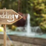 Coma Patients Reunite in Stunning Love Story Wooden sign pointing towards a wedding venue