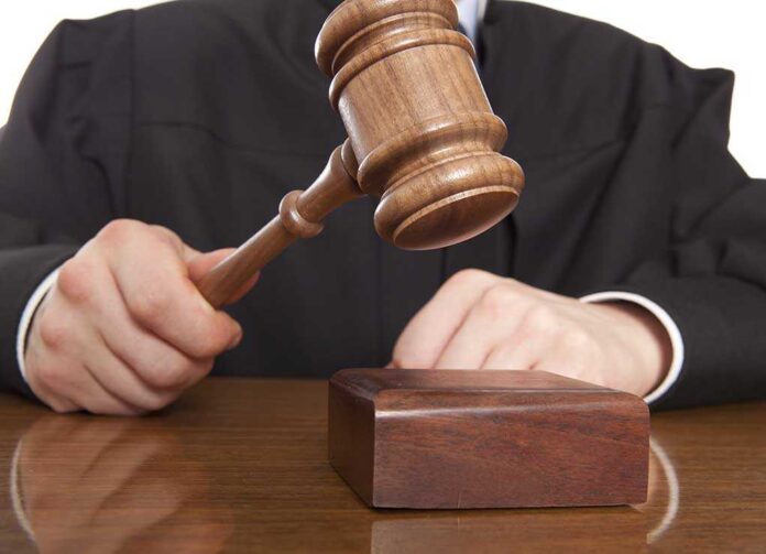 shutterstock_166657157.jpg A judge holding a gavel above a wooden block