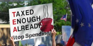 Protesters holding signs against taxation at a political demonstration