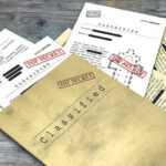 Epstein Files REDACTED – Trump Accused of Cover-Up Classified documents with Top Secret stamps on wooden surface.
