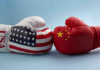 USA and China boxing gloves facing each other.
