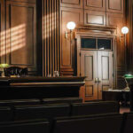 Mysterious Lover Testifies—Jealousy Sparked Murder Empty courtroom with judges bench and wooden decor.