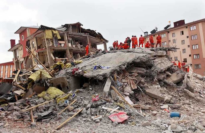 Rescue workers in orange uniforms on a collapsed building site after an earthquake