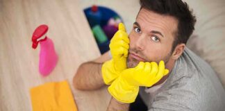 Man in yellow gloves looking frustrated while preparing to clean