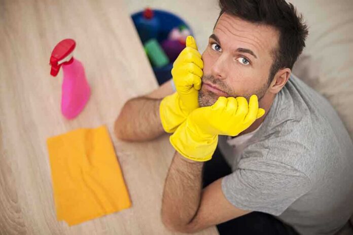 shutterstock_167358833.jpg Man in yellow gloves looking frustrated while preparing to clean