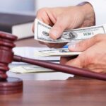 $1 Million Gold Card Sparks Immigration Uproar A person counting cash in a courtroom setting with a gavel in the foreground