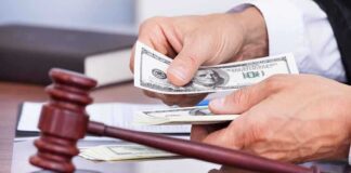 A person counting cash in a courtroom setting with a gavel in the foreground