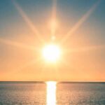 Massive Solar Eruption Imminent? 3 Days to Prepare A serene sunrise over a calm ocean with vibrant colors in the sky