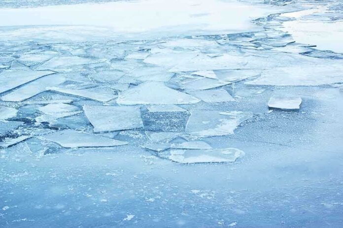 A frozen lake with cracked ice and blue hues