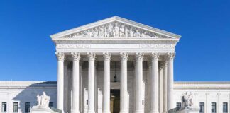 The Supreme Court building featuring marble columns and a clear blue sky