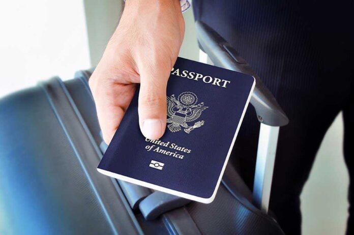 shutterstock_212653228.jpg A person holding a United States passport next to a suitcase