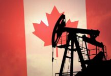 Silhouette of an oil rig against the Canadian flag