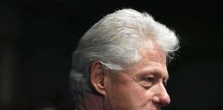 Profile portrait of a man with gray hair in formal attire