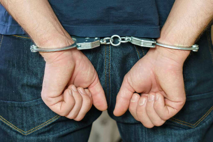 1916737259 Person in handcuffs behind their back.