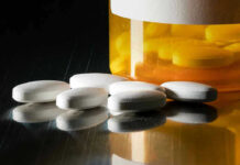Doctors Penalize Pain Patients Amid Opioid Panic White pills beside an orange pill bottle.