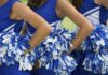 Cheerleaders in blue and white uniforms holding pom poms