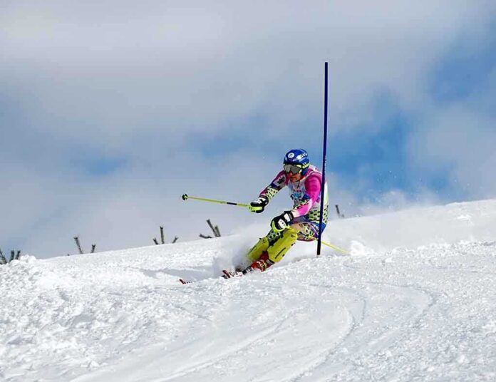 shutterstock_11683363.jpg Athlete skiing down a snowy slope around a slalom pole