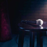 Microphone resting on a stool on stage.