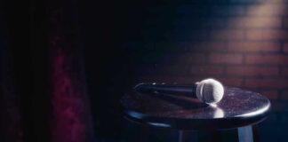 Microphone resting on a stool on stage.