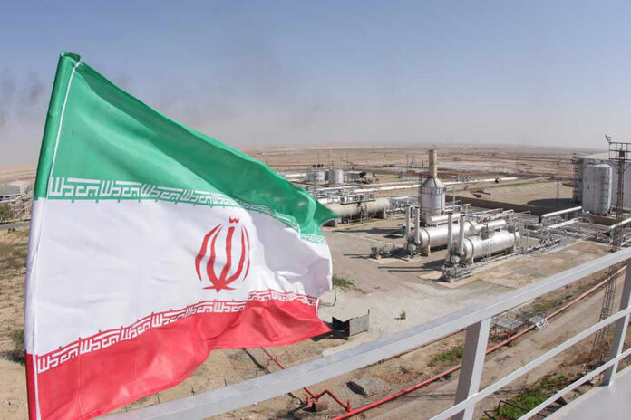 1227310843 Iranian flag near an industrial gas refinery.