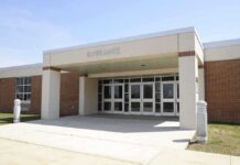 Entrance of a modern school building with glass doors and a brick facade