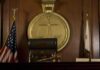 A judges bench in a courtroom with a gavel and legal symbols
