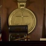 A judges bench in a courtroom with a gavel and legal symbols