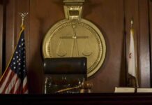A judges bench in a courtroom with a gavel and legal symbols