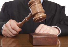A judge holding a gavel above a wooden block