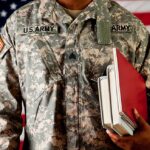 Army Desperation: Enlistment Age Jumps to 42 A soldier in a U.S. Army uniform holding books in front of an American flag