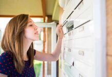 A woman checking her mailbox in an outdoor setting